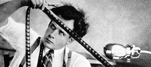 Sergey Eisenstein looks at a strip of motion picture film
